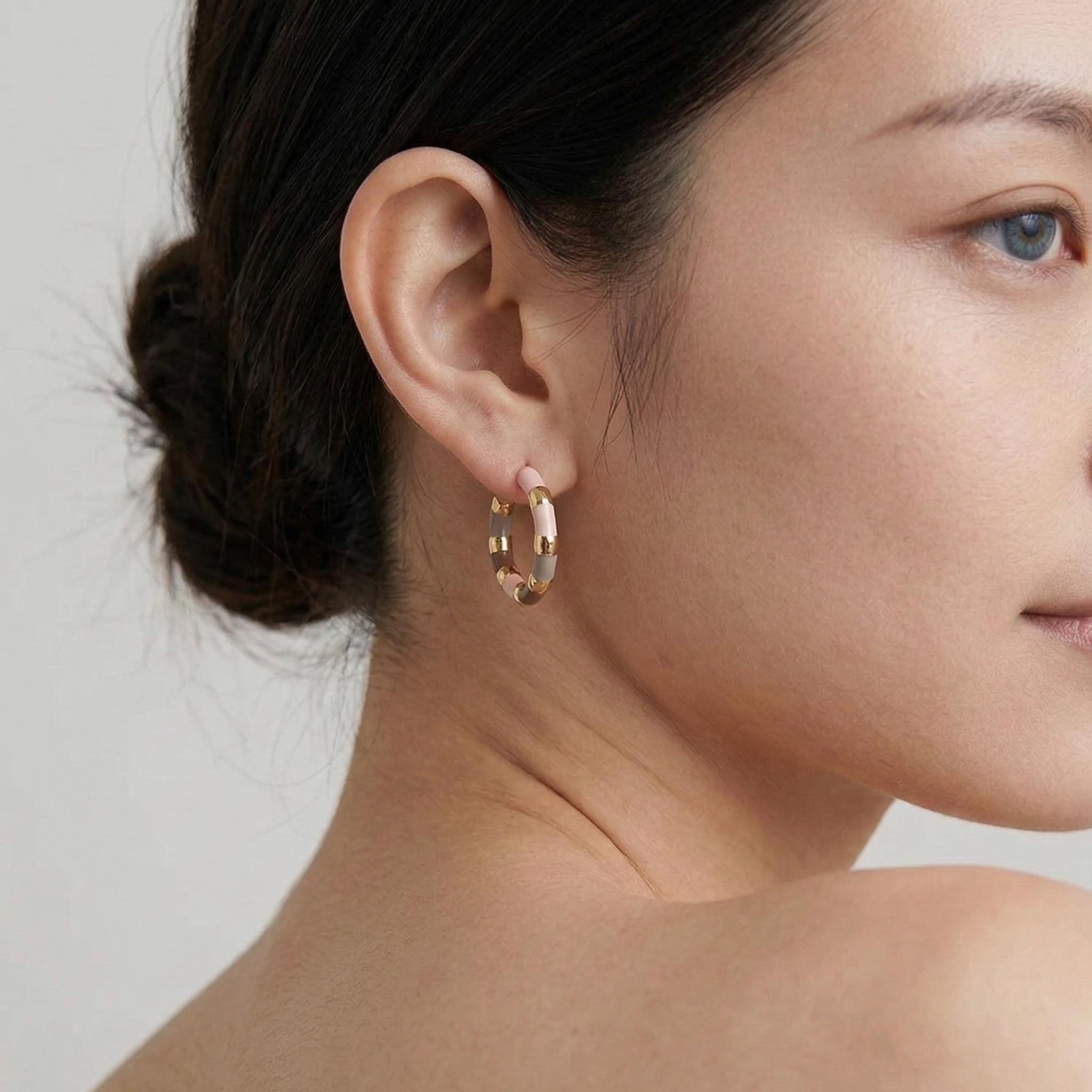 Woman wearing pastel enamel hoop earrings